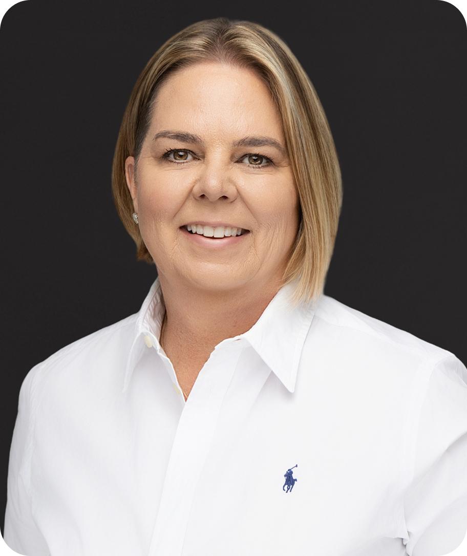 http://Kelli%20House,%20M.A.,%20headshot.%20Smiling%20woman%20in%20white%20shirt%20against%20a%20dark%20background.